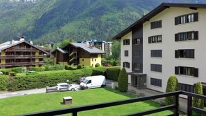 Ein Hotel mit mehreren Gebäuden, einem Parkplatz und einer Bergkulisse.