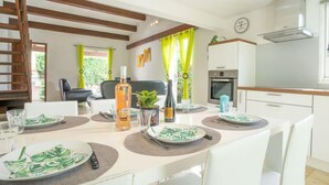 Una cocina moderna con armarios blancos, horno integrado y campana de acero inoxidable.