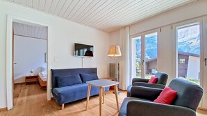 A modern living room with a sofa, armchair, and table.