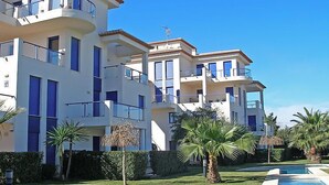 A multi-story residential building with balconies, a swimming pool, and palm trees. - Alma del Sol by Interhome (Dénia)