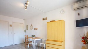 Ein Zimmer mit Bett, Schreibtisch, Stuhl, Kleiderschrank und Fernseher.