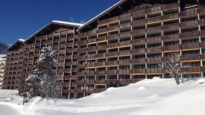 Un hotel de varios pisos con balcones, rodeado de nieve.