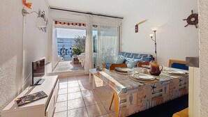 Ein gemütlicher Wohnbereich mit Essplatz, einer Couch und Blick ins Freie.