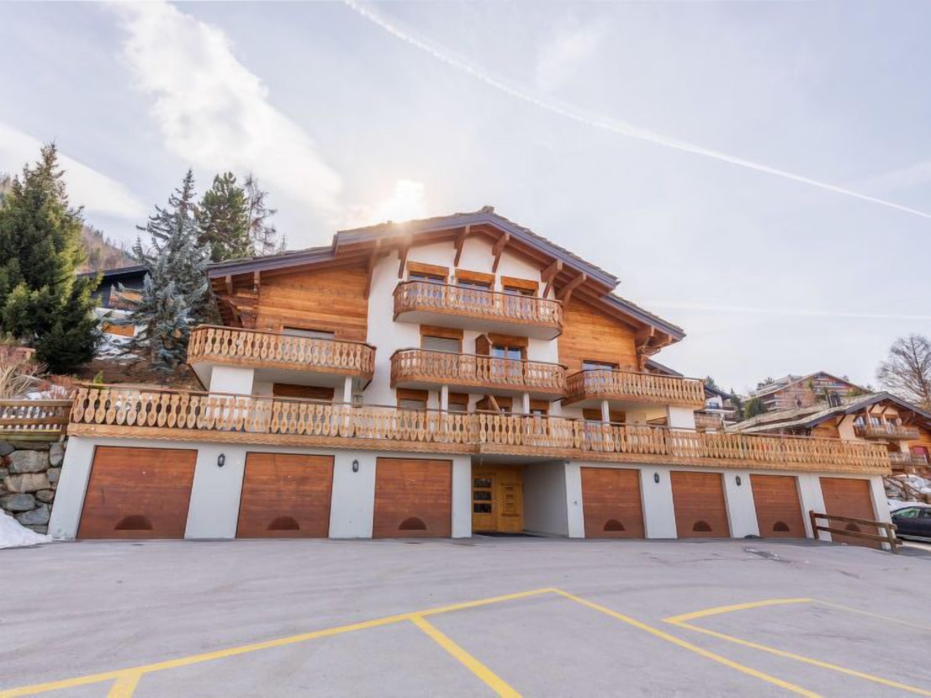 Un immeuble à plusieurs étages doté de balcons en bois et de portes de garage.
