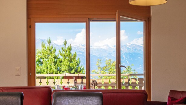 Comedor con vistas a las montañas a través de amplios ventanales.