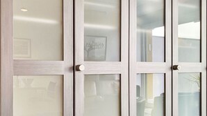 A set of frosted glass doors with a light wood frame, reflecting interior lighting and a tree outside. - Lakeview App 501 by Interhome (Ascona)