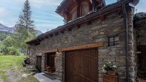 A rustic stone building with wooden doors and a stone pathway leading to the entrance. - Chez Les Roset by Interhome (Arvier)
