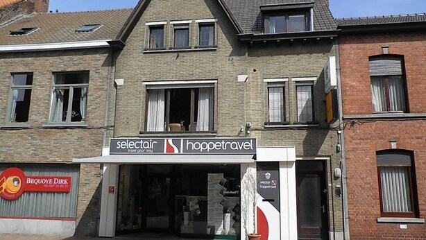 Ein zweistöckiges Gebäude mit einem Schild für 'selectair hoppetravel' im Erdgeschoss.