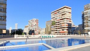 Un espace piscine offrant une vue sur les immeubles modernes qui s’élèvent en arrière-plan.