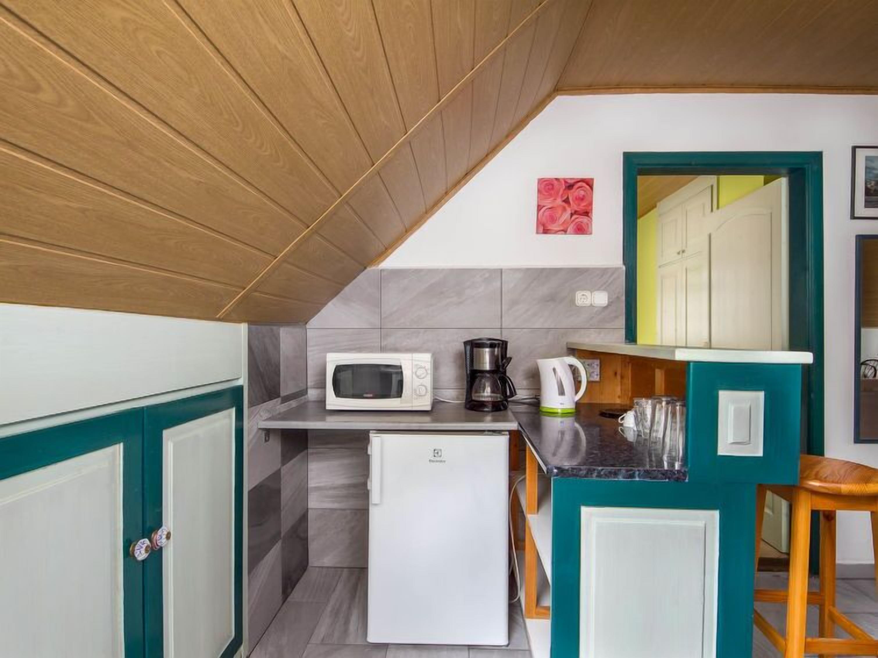 A compact kitchen with a microwave, coffee maker, and small refrigerator.