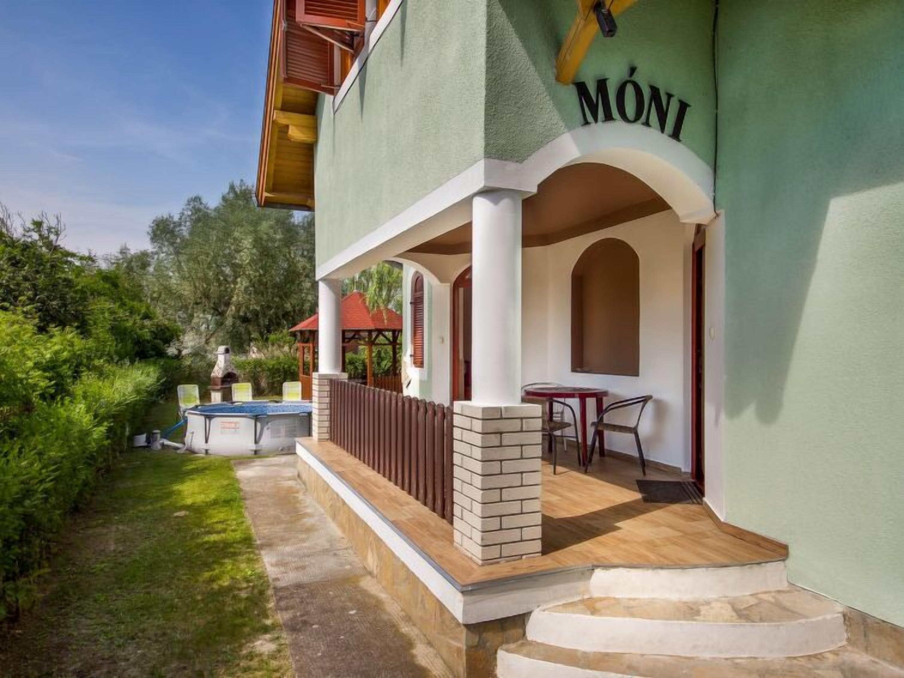 Un edificio con un espacio al aire libre cubierto, una piscina y un patio con mesa y sillas.