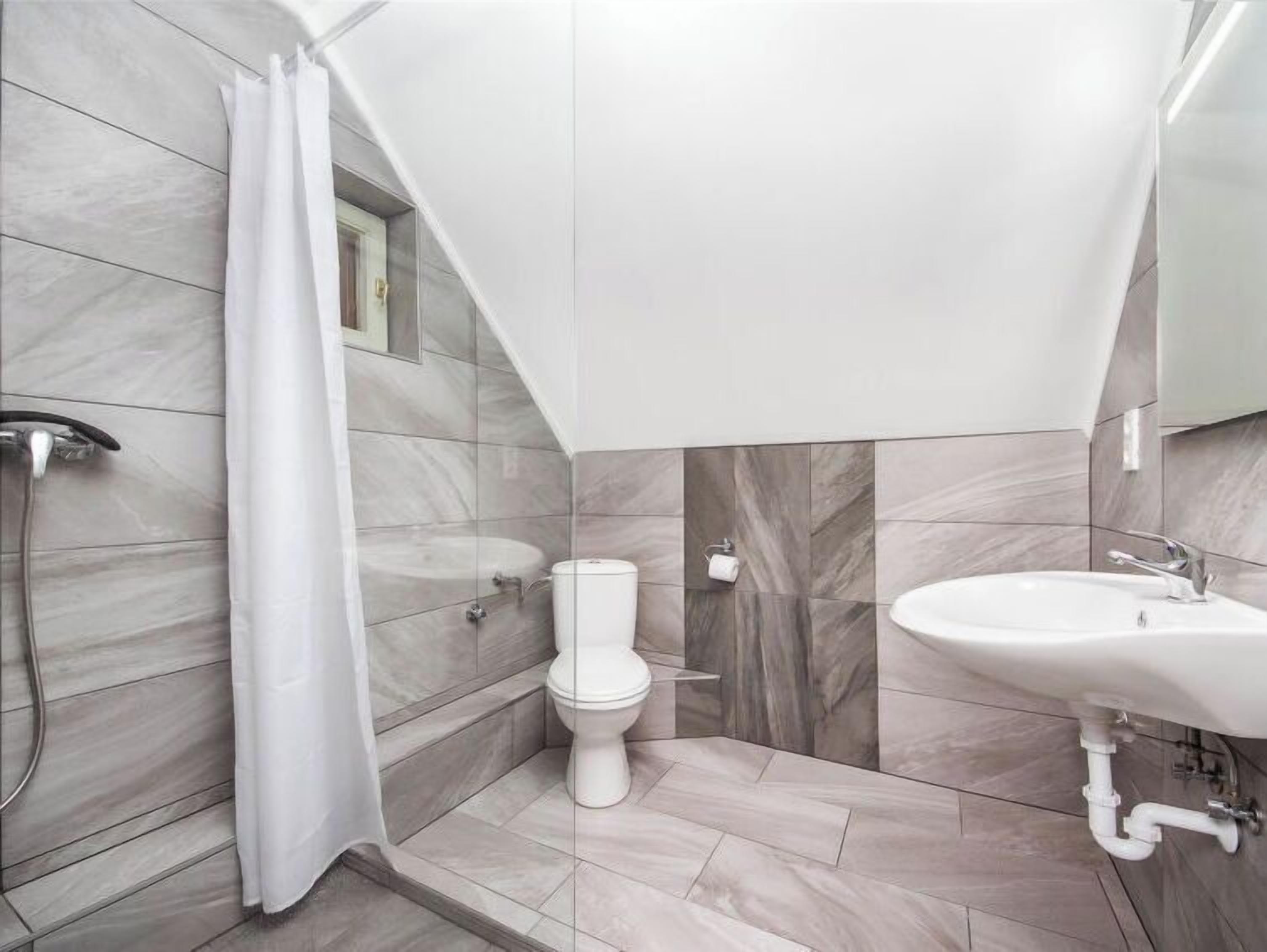 Un baño moderno con ducha, inodoro y lavamanos.