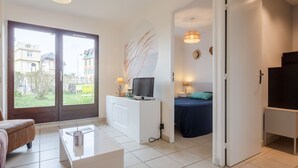 Ein modernes Wohnzimmer mit Sofa, Couchtisch, Fernseher und Essbereich.