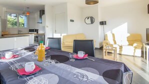 Una sala moderna con una mesa de comedor para dos, un sofá y una silla.