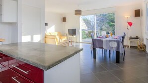 Una cocina moderna con comedor, ventanas amplias y vistas al exterior.
