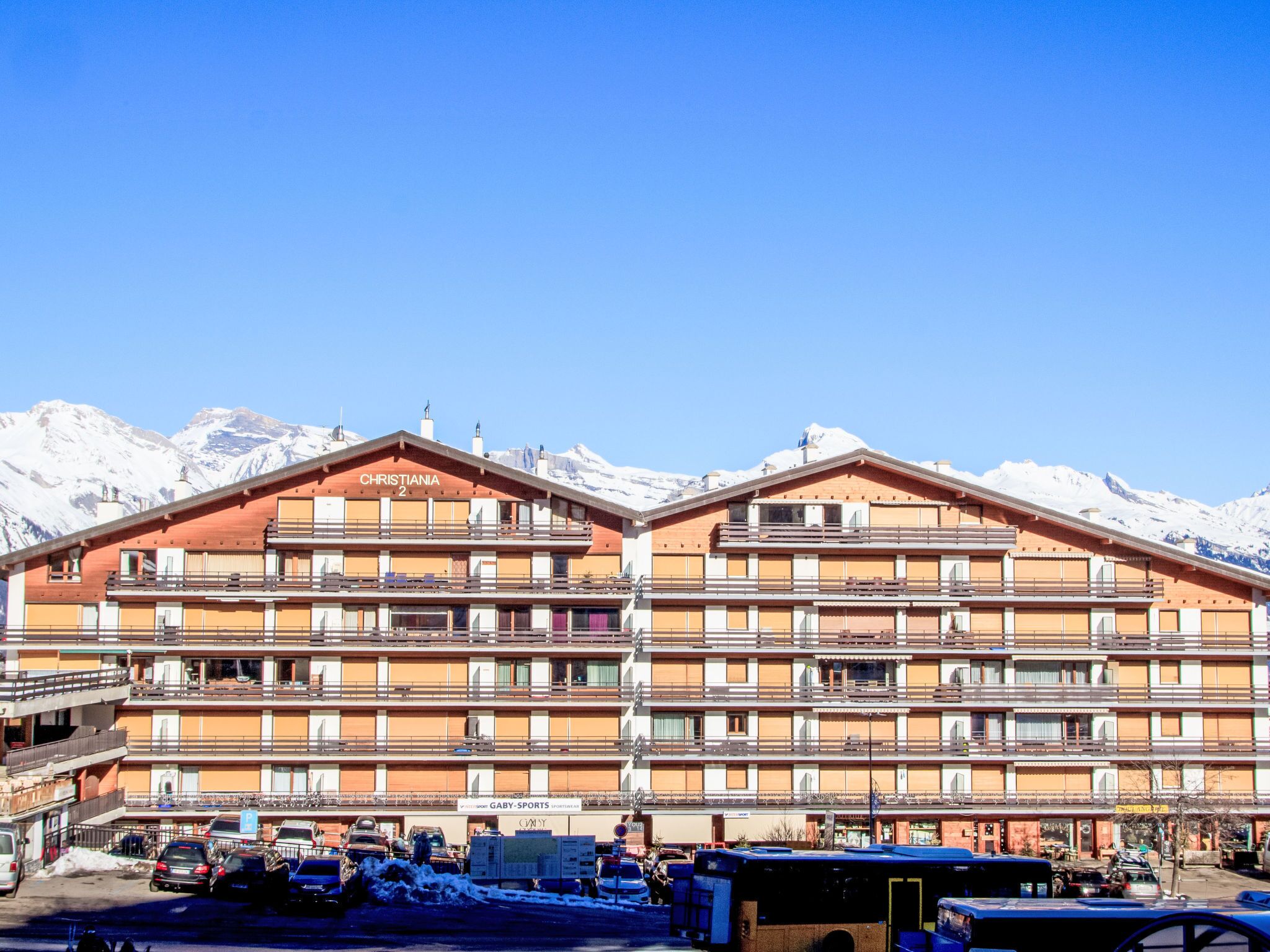 A multi-story hotel with a ski slope in the background.