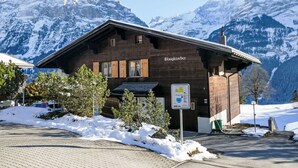 Eine Holzhütte mit einem Schild, auf dem 'Blaugatscher' steht, in einer verschneiten Berglandschaft.
