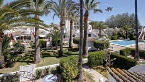 Een resort met meerdere villa's, een zwembad en weelderige palmbomen.