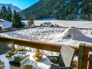 A dining area with a view of a snowy landscape and mountains.