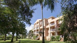 A multi-story hotel with balconies, surrounded by well-maintained lawns and trees. - Apartment Keops by Interhome (Oliva)