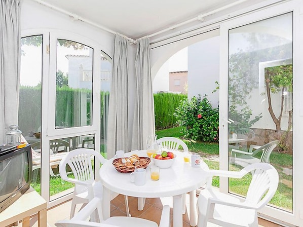 A dining area with a round table, white chairs, and a breakfast setting.