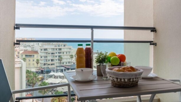 A balcony with a table set for breakfast, including a bowl, croissants, and fruit. - Apartment Casino by Interhome (Canet-Plage)