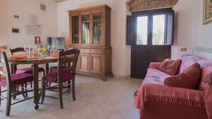 Un coin repas comprenant une table et des chaises en bois, un buffet et un canapé.