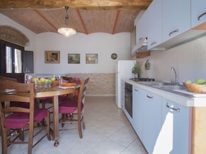 Une cuisine équipée d’une table à manger, de chaises, d’un évier et de placards.