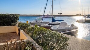 A marina with boats docked, a clear sky, and a sun reflecting on the water. - Marina 2 by Interhome (Saint Cyprien)