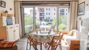 A modern living room with a dining table, wooden chairs, a sofa, and a kitchen area. - Marina 2 by Interhome (Saint Cyprien)