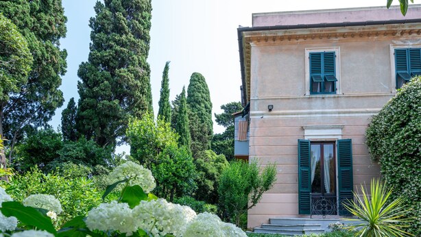 A building with a symmetrical facade, a gravel driveway, and a variety of greenery including trees and flowering plants. - Bagnolo by Interhome (Albisola)