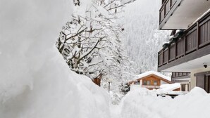 Un edificio cubierto de nieve con fachada de madera y balcones.