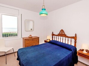 Une chambre à coucher comprenant un lit, une commode, une table de chevet, une lampe, un miroir et une fenêtre donnant sur un paysage agréable.
