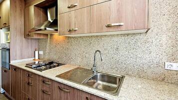 Een koelkast, een magnetron, een oven, kookgerei, borden en bestek