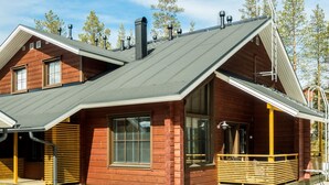 Une cabane avec un toit en pente, de grandes fenêtres et une terrasse en bois.