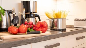 A kitchen counter with a coffee maker, a pot of spaghetti, fresh tomatoes, and a red bell pepper. - Vacation home Butzel by Interhome (Norddeich)