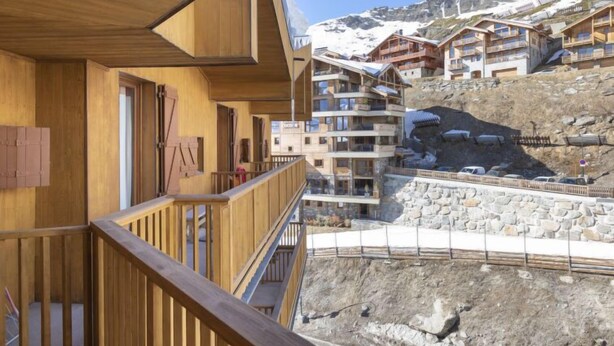 A wooden building with balconies overlooking a snowy mountain. - Roche Blanche 83 by Interhome (Val Thorens)