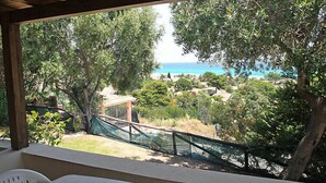 A covered outdoor seating area with a view of the sea and surrounding greenery. - Belvedere Bilo by Interhome (Costa Rei)