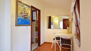 Una stanza con una scrivania, una sedia e un quadro raffigurante una barca a vela.