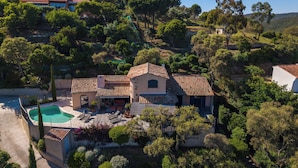 Uma villa em estilo mediterrâneo, com piscina, telhas de terracota e vegetação exuberante.