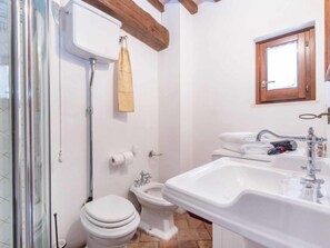 Une salle de bain équipée d’une douche, de toilettes, d’un bidet et d’un lavabo.