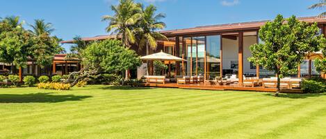 Un resort moderno con césped bien cuidado, zonas de estar al aire libre y jardines tropicales.