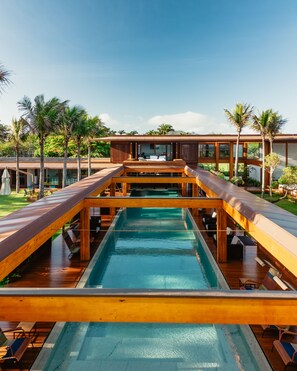 A modern resort with a central pool, wooden deck, and palm trees. - Zendaya Resort Beach Sport & Spa (Búzios)