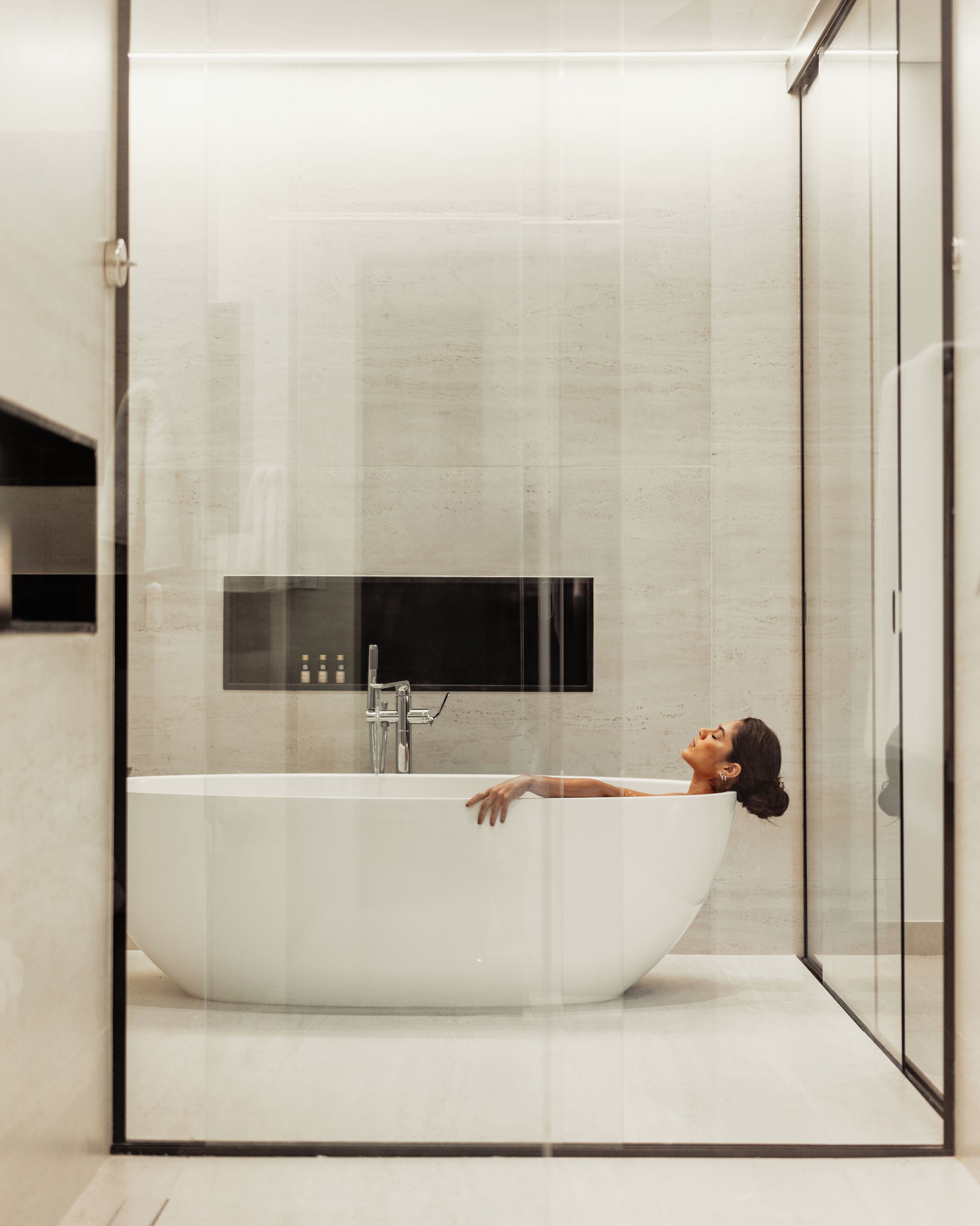 A modern bathroom with a freestanding bathtub, a glass shower enclosure, and a minimalist design.