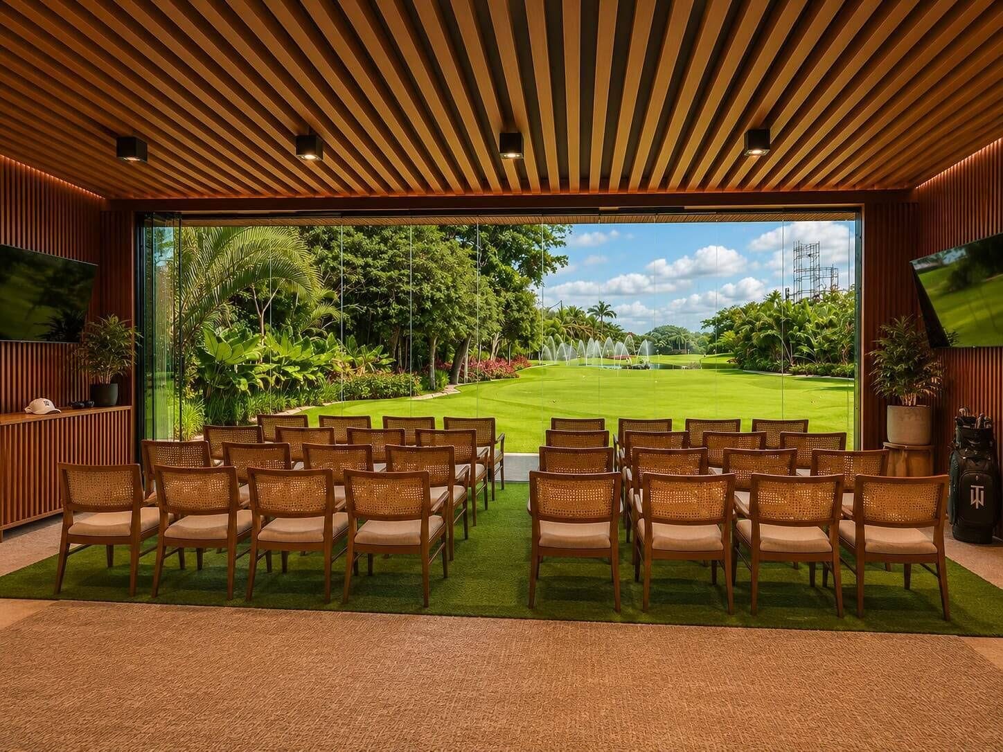 Una habitación con vistas a un campo de golf, paneles de madera y sillas de mimbre.
