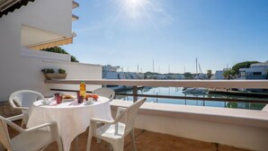 A terrace with a white table and chairs, overlooking a marina with boats. - Les Marinas d'Ulysse IV by Interhome (Port Camargue)