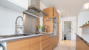 Een moderne keuken met houten kastjes, roestvrijstalen apparatuur en een ingebouwde oven.