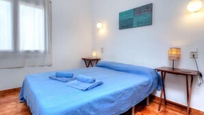 A room with a bed, a small table, a lamp, and a painting on the wall. - Sant Carles by Interhome (Llançà)