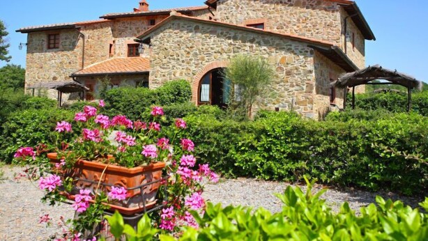 A stone building with a courtyard, featuring a large archway and a pergola. - Pulcino n°3 by Interhome (Gaiole in Chianti)