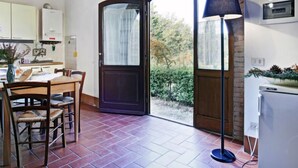 A cozy kitchen with a dining area, a large window, and a cross on the wall. - Pulcino n°3 by Interhome (Gaiole in Chianti)